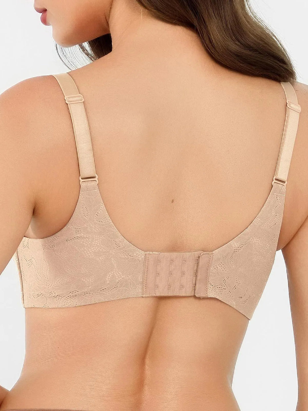Back view of woman wearing nude beige bra showing adjustable straps, lace texture, and three-hook closure band