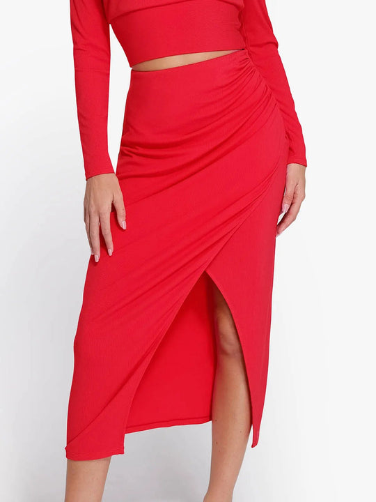 Red ribbed modal midi wrap skirt with elegant drape, side slit, and built-in sculpting.