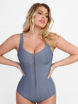 Blue denim tummy control corset bodysuit with front zipper and shaping seams.