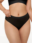 Black seamless solid mid-rise thong brief with comfortable elastic waistband.