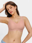 Seamless pink wireless ruched comfort minimizer bra on a woman, highlighting stretch fabric and support.