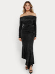 Woman in black metallic knit mermaid maxi dress with off-the-shoulder neckline and long sleeves.