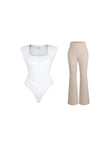 White padded shoulder slimming bodysuit with asymmetric ruched waistline and beige flare-leg pants.