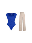 Blue padded shoulder bodysuit with ruched waist and beige wide-leg pants