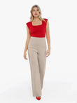 Red padded shoulder square neck bodysuit with beige wide-leg pants.