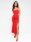 Woman in red ruched side slit maxi dress highlighting slimming fit and elegant style.