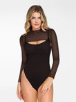 Woman wearing a black long-sleeve mesh shrug over a black sculpting bodysuit with a chest cutout.