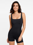 Black square neck strappy shapewear romper with waist toning ribbed paneling and short legs.